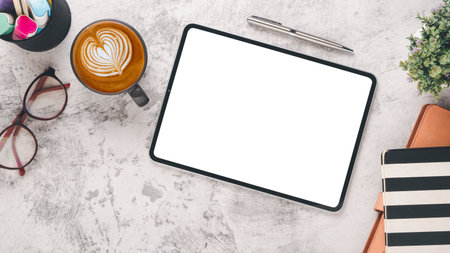 White desk workplace with blank screen laptop computer, notebook, eyeglass, pen and cup of coffee, Top view flat lay.の写真素材