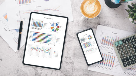 Tablet and smart phone with charts and reports on office desk workplace. Top view flat layの写真素材