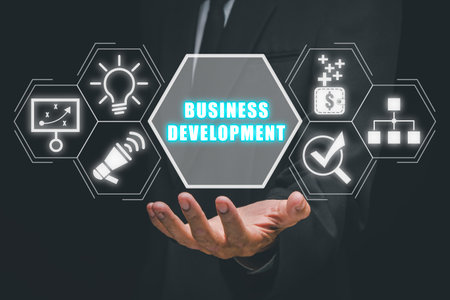 Business development concept, Business person hand holding business development icon on virtual screen.の写真素材