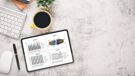 Tablet with charts and reports on office desk workplace. Top view flat layの写真素材