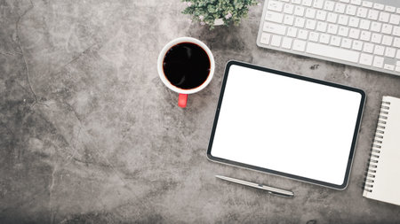 Office desk workplace with blank screen tablet, pen, notebook, keyboard and cup of coffee, Top view...