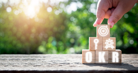 OKR, Objectives and Key Results concept, Hand holding wooden block with Objectives and Key Results icon on virtual screen, Methods for project management.の写真素材