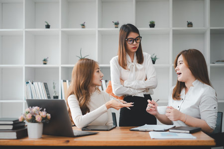 Serious team of professionals, Three multi ethnic business people negotiating in modern boardroom, discuss project, consider contract terms and conditions, solve business.の写真素材