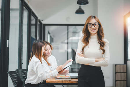 Successful businesswoman standing in creative office and looking at camera. Woman entrepreneur in a coworking space smiling.の写真素材