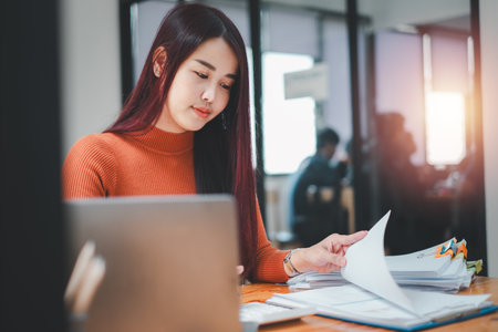 Portrait of Young Successful Caucasian Businesswoman sitting at desk working on laptop computer. Ambitious Corporate Manager Plan Investment Strategy for e-Commerce Project.の写真素材