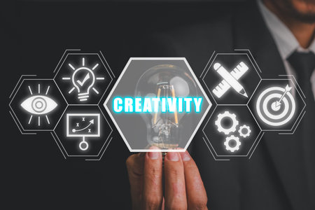 Creativity concept, Businessman hand holding light bulb with creativity icon on virtual screen.の写真素材