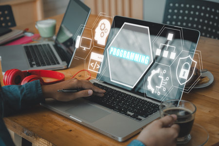 Programming concept, Person working on laptop computer with programming icon on virtual screen.の写真素材
