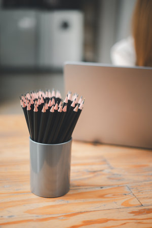Many black pencils in basket on office desk.の写真素材