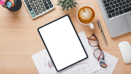 A tablet sits on a desk with a cup of coffee and a pen. The tablet is empty, and the coffee cup has...