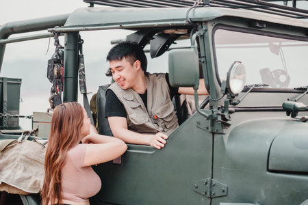 Young couple sharing a smile and a conversation inside a off-road car, creating a personal memory.