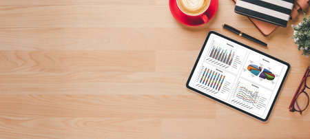 A tablet with a red cup on top of it. The tablet is displaying a graph with a red lineの写真素材