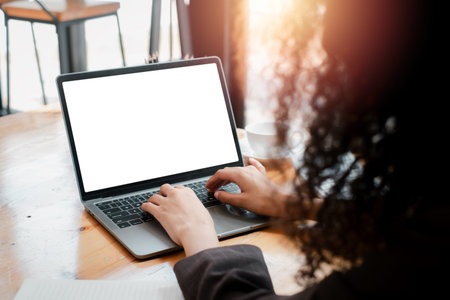 Close-up back view of a business woman working in the office typing, looking at the screen. office...