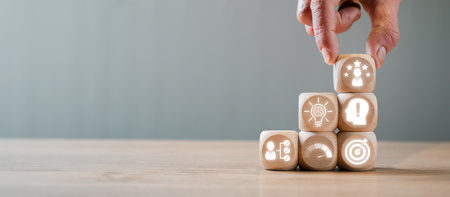 Hand arranging wooden blocks with competence concept icons, symbolizing skills, growth, and success in business and personal development.の写真素材