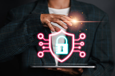 Businessman holding a tablet with a glowing shield and lock icon, symbolizing cyber insurance, digital security, and protection in the modern business world.の写真素材