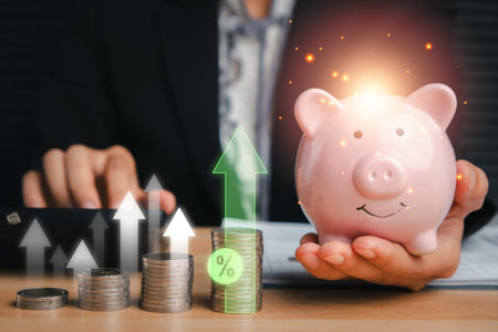 Visual representation of financial growth with a piggy bank, stacked coins, and upward arrows symbolizing interest and dividends.の写真素材
