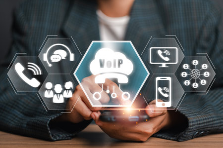 A visual representation of Voice over Internet Protocol (VoIP) technology, showcasing digital communication icons and a smartphone in a professional setting.の写真素材