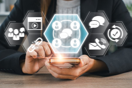 A person using a smartphone with digital icons symbolizing communication, connectivity, and modern technology in a business context.の写真素材