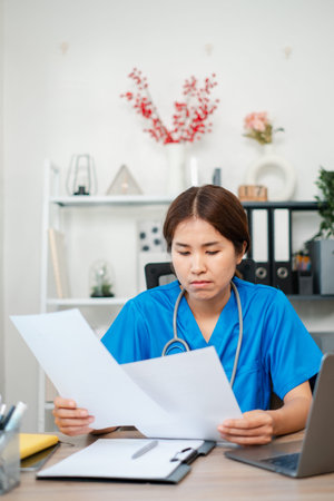 A dedicated nurse in blue scrubs examines paperwork at a desk, surrounded by office supplies and...