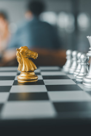 Close-up of a golden knight chess piece on a chessboard, symbolizing strategy and competition.の写真素材