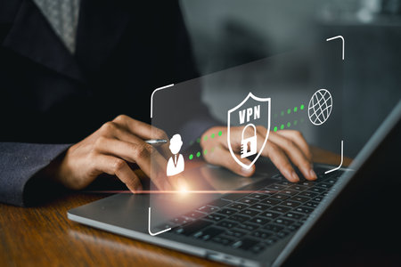Hands typing on a laptop with a digital VPN shield icon, symbolizing online security, privacy, and data protection.の写真素材