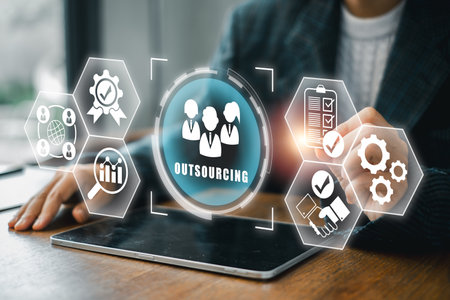 Visual representation of outsourcing with digital icons and business elements on a tablet in a contemporary office setting.の写真素材