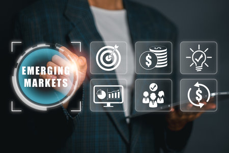 Businessman interacts with digital icons representing emerging markets, showcasing growth, finance, and innovation.の写真素材