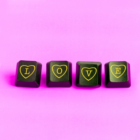 Love and computer buttons on a pink backgroundの写真素材