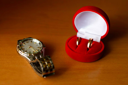 wedding ring in a box and watches on the table