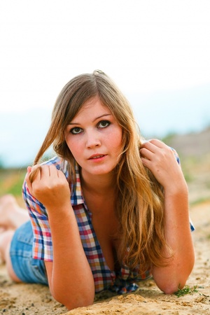 blonde woman with large breasts plaid shirt and jeans in the sand and keeps hairの写真素材