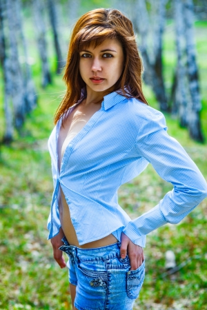 sexy brunette woman in a blue shirt and shorts on the nature ofの写真素材