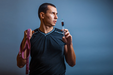 male of European appearance brunette holding a tourniquet and syの写真素材
