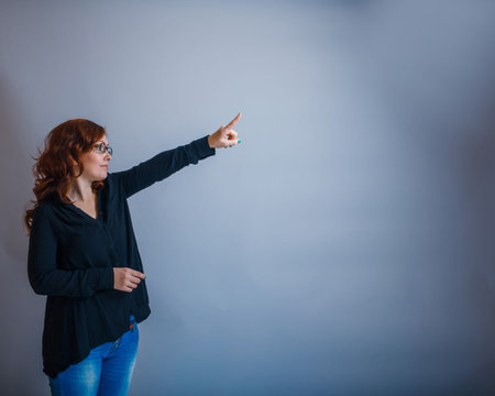 European - looking  woman  of  30  years  is pointing in the  diの写真素材