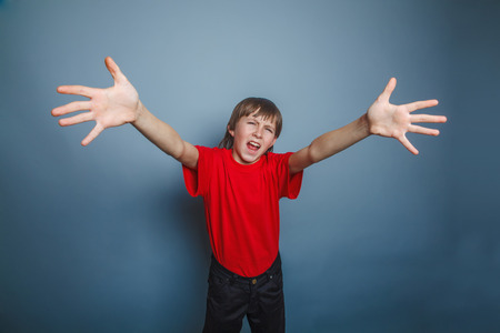European-looking boy of ten years held out his hands, palms forwの写真素材