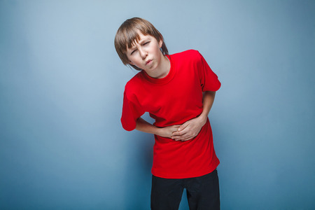 Boy teenager twelve years in the red shirt abdominal pain, gastritis, diarrheaの写真素材