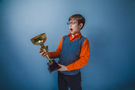 European-looking boy of ten years award cup on gray の写真素材