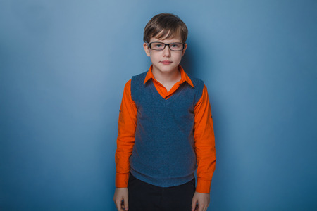 European-looking boy of ten years in glasses award portrait on gray の写真素材