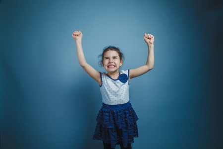 a girl of seven European appearance brunette shows muscles handsの写真素材