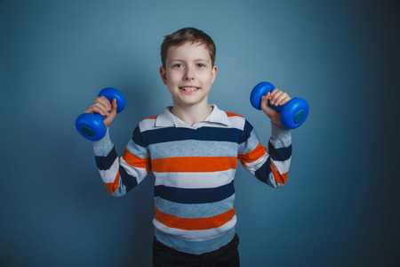 teenager boy brown European appearance holds a blue dumbbell の写真素材