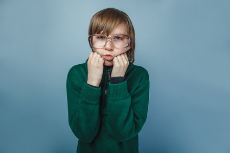 European-looking boy of ten years in glasses  shows fists  の写真素材