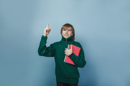 European-looking boy of ten years in glasses holding a book の写真素材