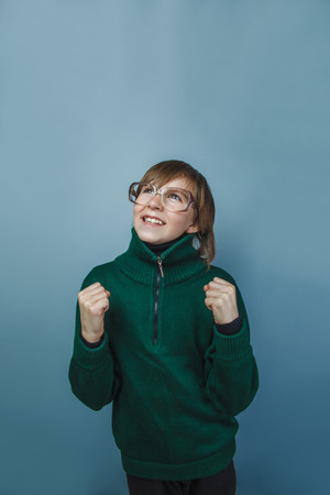 European-looking boy of ten years in glasses rejoices victory の写真素材