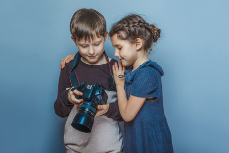 Teenage boy with a girl watching pictures on the camera on a graの写真素材