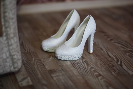 White female shoes with heels  are on the floorの写真素材