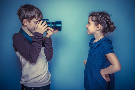 Teenage boy about seven years old girl photographed in the professional camera on a gray background, joy, model, pose retro photo effectの写真素材