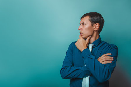 a man of European appearance thirty years, he recalls thinking on  a  gray  backgroundの写真素材