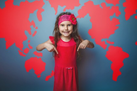 a girl of seven European appearance brunette sad thing keeps fingers on a gray background, discontentの写真素材