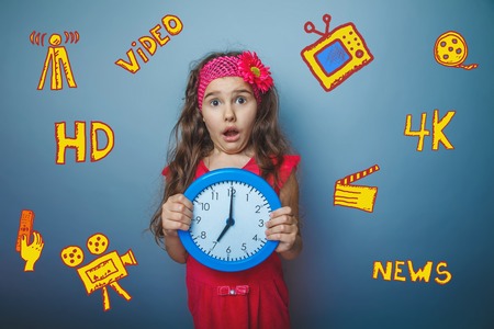 a girl of seven European appearance brunette sad thing keeps fingers on a gray background, discontentの写真素材