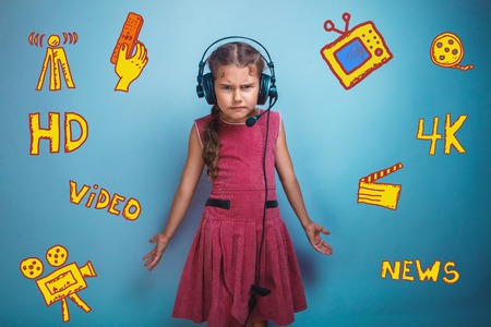 a girl of seven European appearance brunette sad thing keeps fingers on a gray background, discontentの写真素材