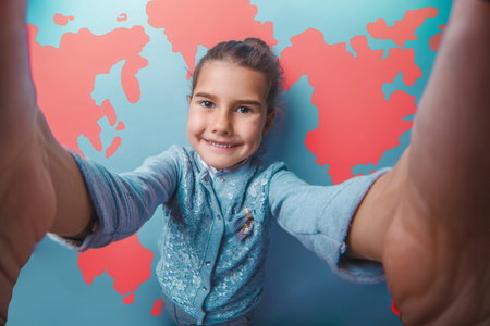 girl  teen shouting stretched her arms behind world map education backgroundの写真素材