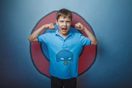 Boy superhero teenager raised his arms shouting strength power blue maskの写真素材